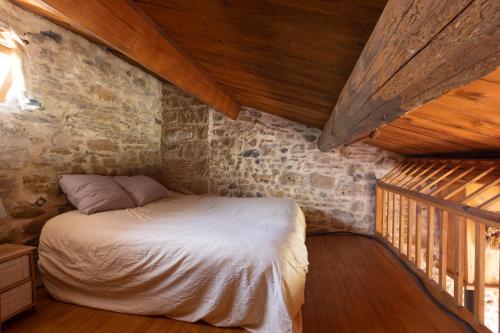 une chambre avec un lit dans une pièce avec des plafonds en bois dans l'établissement Maisonnette de campagne proche du lac du Salagou, à Brenas