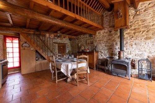 - une salle à manger avec une table et un poêle à bois dans l'établissement Maisonnette de campagne proche du lac du Salagou, à Brenas