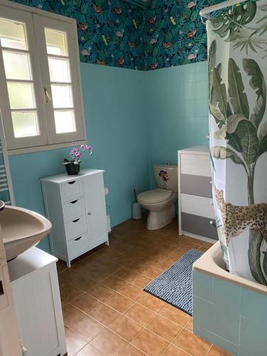 une salle de bain bleue avec des toilettes et un lavabo dans l'établissement Maison périgourdine 144m2, à Piégut-Pluviers