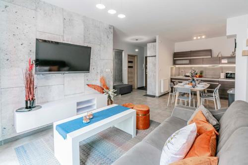een woonkamer met een bank en een tafel bij Apartament Riwiera dla 2 par i 2 dzieci, 300 m od plaży in Władysławowo