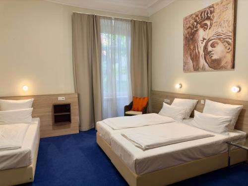 a hotel room with two beds and a window at Hotel Central in Bamberg