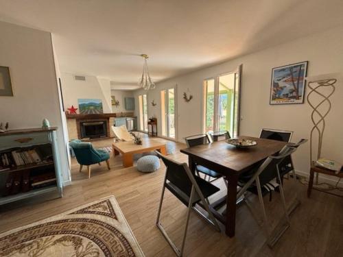 un salon avec une table et des chaises en bois dans l'établissement Villa bord de mer Appietto LAVA, à Appietto