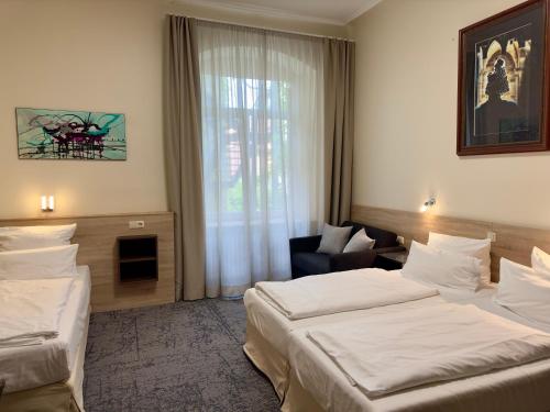 a hotel room with two beds and a window at Hotel Central in Bamberg