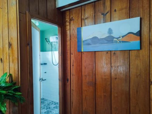 een badkamer met een douche en een foto aan de muur bij Rm 202 Mhapiya-aw Pensione Inn in Sagada