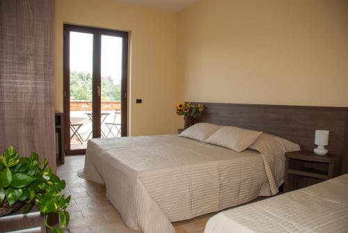 una camera con 2 letti e un balcone di Casa Dèlfico Ristoro in famiglia a Teramo