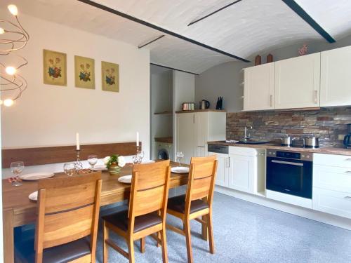 eine Küche mit einem Esstisch aus Holz und Stühlen in der Unterkunft Ferienhaus "Am Papststein" in Kurort Gohrisch