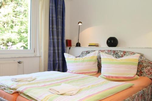 a bed with two towels on it with a window at Ferienhaus "Am Papststein" in Kurort Gohrisch