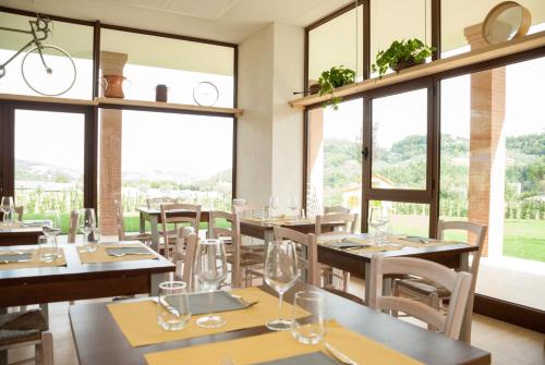 ein Restaurant mit Tischen und Stühlen und großen Fenstern in der Unterkunft Casa Dèlfico Ristoro in famiglia in Teramo