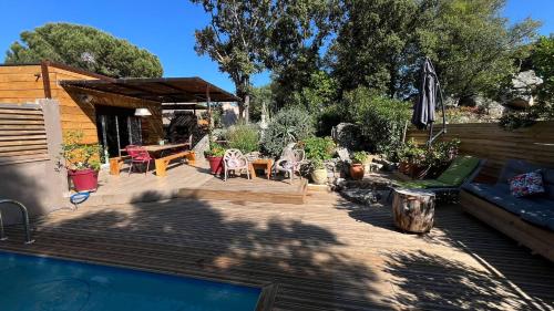 une arrière-cour avec une piscine et une terrasse en bois dans l'établissement Villa A Liccia piscine 4pers proche Ville et Port, à Porto-Vecchio