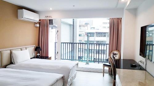 a hotel room with two beds and a balcony at Taichung EnrichLife Hotel in Taichung