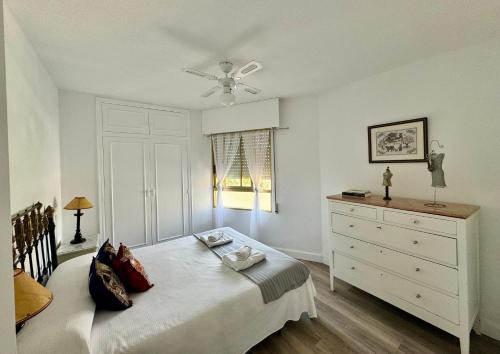 贝尼多姆Garay Apartments的带白色床和梳妆台的卧室