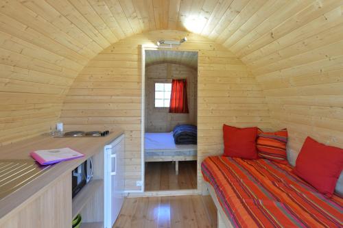 Cette petite chambre comprend un lit dans une cabane en bois. dans l'établissement Camping Chambord, à Mont-près-Chambord