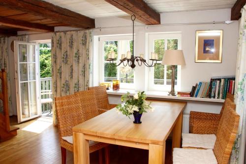 a dining room with a table and chairs and windows at Apartmenthaus Brunnenhof in Papstdorf