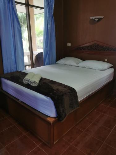 a bed with two slippers on it in a bedroom at Rainbow Bungalow Haadrin Koh Phangan in Haad Rin