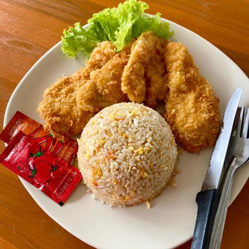 a plate of food with chicken and rice on a table at Rainbow Bungalow Haadrin Koh Phangan in Haad Rin