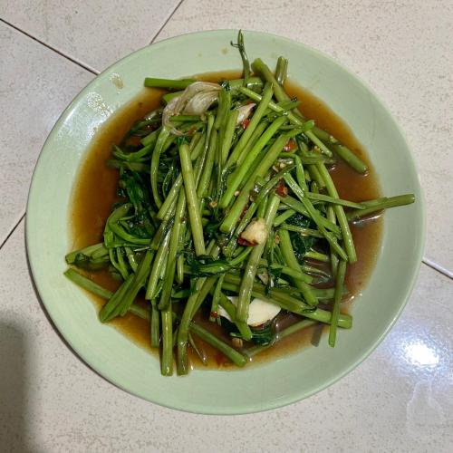 a bowl of soup with green vegetables in it at Rainbow Bungalow Haadrin Koh Phangan in Haad Rin