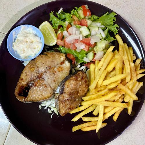 a black plate of food with french fries and vegetables at Rainbow Bungalow Haadrin Koh Phangan in Haad Rin