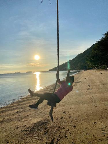 a person on a swing on the beach at Rainbow Bungalow Haadrin Koh Phangan in Haad Rin