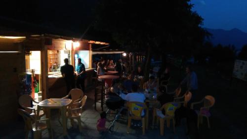 a group of people sitting at tables and chairs at night at Agriturismo Val Codera in Verceia