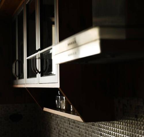 a light above a counter in a bathroom at Luxury Hill Top Apartment by EWA Properties in Mangalore
