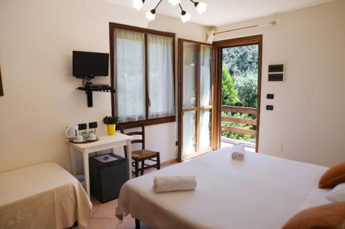 um quarto com uma cama, uma secretária e uma janela em Villa Gaia em Portoferraio