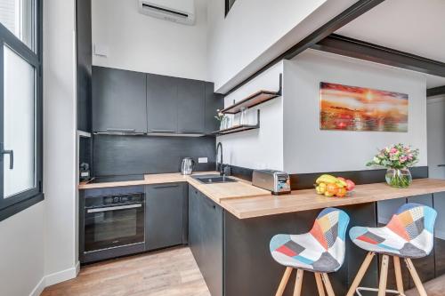 une cuisine avec un comptoir et deux tabourets dans l'établissement BRP Cannes Center, Two-Bedroom Deluxe Apartment, à Cannes