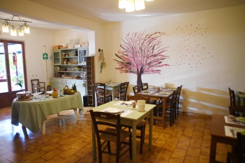 a dining room with tables and a tree on the wall at Villa Gaia in Portoferraio