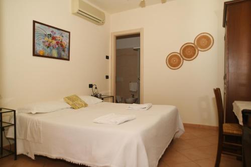 a bedroom with a bed with white sheets and a picture on the wall at Villa Gaia in Portoferraio