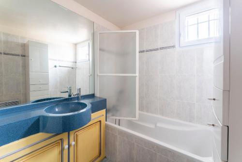 uma casa de banho com um lavatório azul e uma banheira em Le Mazet de Leon em Arles