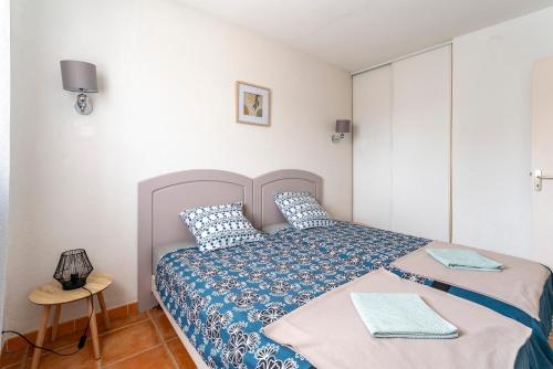 um quarto com uma cama com um edredão azul e branco em Le Mazet de Leon em Arles