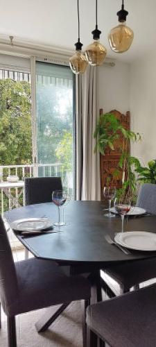 - une salle à manger avec une table et des verres à vin dans l'établissement Location saisonnière logement les pieds dans l’eau, à La Seyne-sur-Mer
