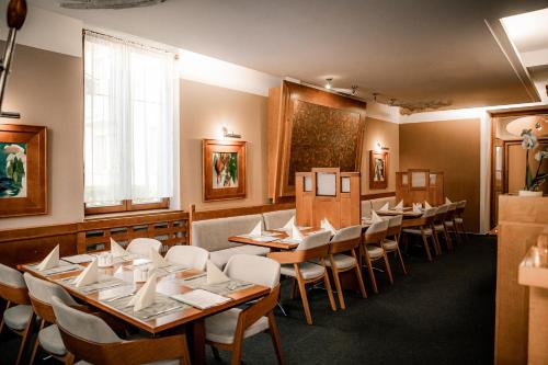 una sala da pranzo con tavoli e sedie in legno di Hotel Iberia a Opava