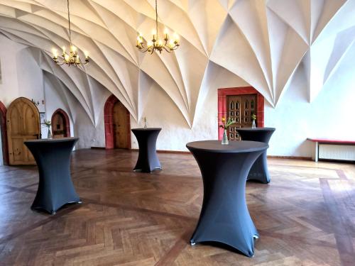 a room with three tables in the middle of a room at Schloss Hotel Wurzen in Wurzen