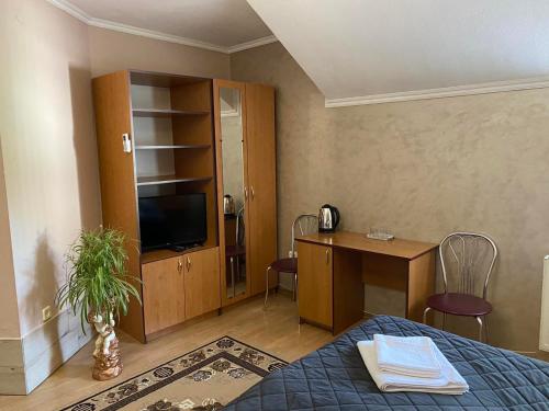 sypialnia z łóżkiem, biurkiem i telewizorem w obiekcie Hotel Zoloti Vorota w mieście Lalovo