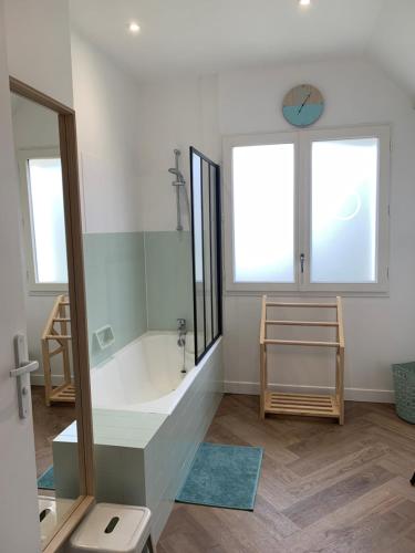 une grande salle de bain avec une baignoire et un lavabo dans l'établissement St Malo - Rothéneuf, proche Mont St Michel et Cancale, grande maison familiale, à Saint-Malo