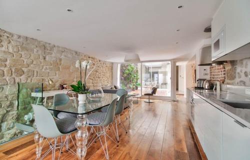 une cuisine et une salle à manger avec une table et des chaises dans l'établissement Jardin Prive - Gorgeous 3 Bed House in Le Marais, à Paris
