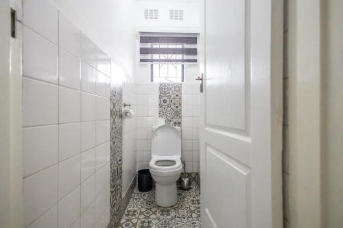 a bathroom with a toilet with a tiled floor at Safi Luxury Apartment 7 in East London