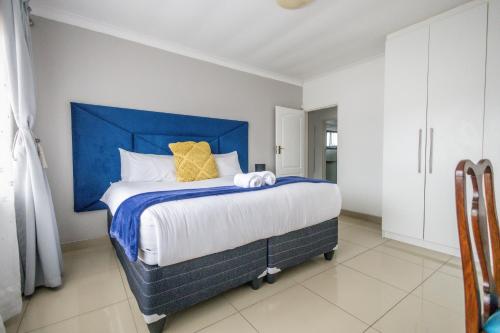a bed with a blue headboard in a bedroom at Safi Luxury Apartment 7 in East London