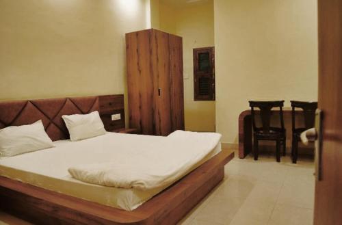 1 dormitorio con 1 cama y 1 silla en Shankars Motel The Royal Regalia, Bhopal en Phanda