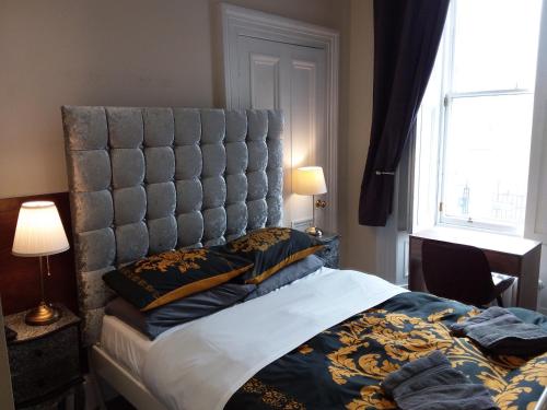 sypialnia z dużym łóżkiem z tapicerowanym zagłówkiem w obiekcie IVY- Braveheart Guest House w Edynburgu