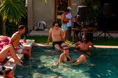 a group of people sitting in a swimming pool at Sepeda Hostel in Canggu