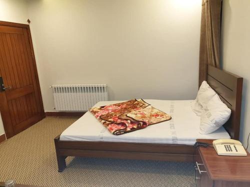 Una cama o camas en una habitación de Rehan Hotel