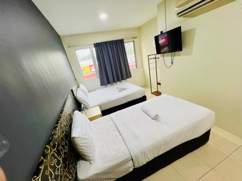 a hotel room with two beds and a tv at Swing & Pillows -MyHome Hotel Wangsa Maju in Kuala Lumpur