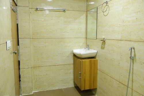 een badkamer met een wastafel en een glazen douche bij Shankars Motel The Royal Regalia, Bhopal in Phanda