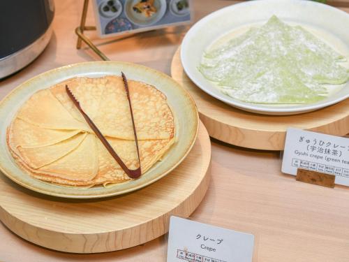 a table with two plates of food on display at REF Kyoto Hachijoguchi by VESSEL HOTELS in Kyoto