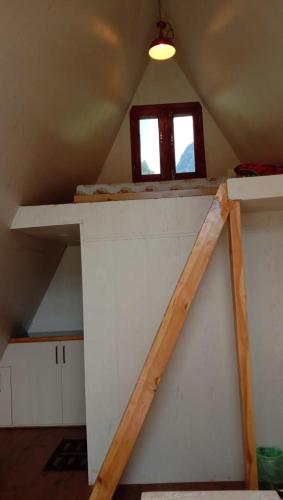 an attic room with a shelf and a window at Mahamaya camping Tosh in Tosh