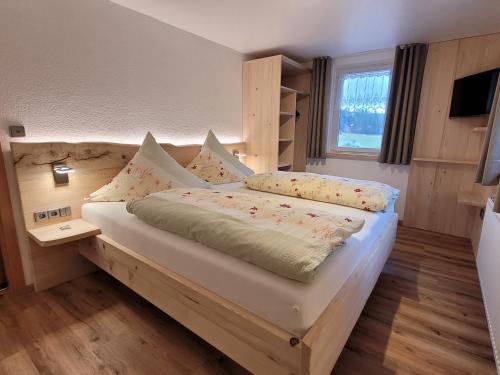 ein Schlafzimmer mit einem großen Bett in einem Zimmer in der Unterkunft Gasthaus Pension Donishäusle in Titisee-Neustadt