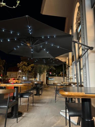 a restaurant with tables and chairs with black umbrellas at Cosmopolita Boutique Hotel in Timişoara