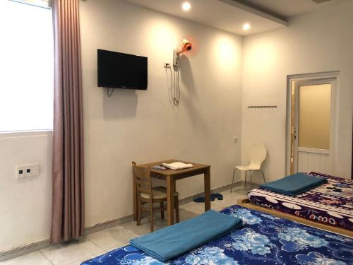 Pokój z 2 łóżkami, stołem i telewizorem w obiekcie Nhà Nghỉ Minh Thảo w mieście Chơn Thành