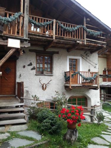 a house with a balcony and flowers in front of it at Baita del Plan in Pragelato